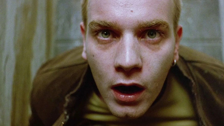 Renton sits in a bathroom stall in "Trainspotting" (1996)