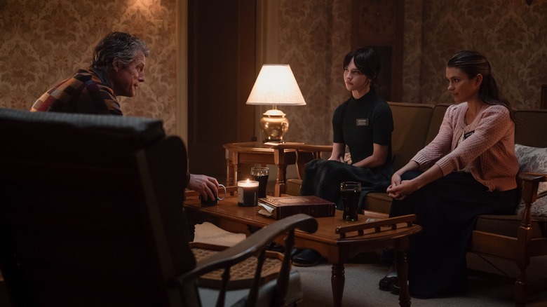 Mr. Reed sits across from Sisters Barnes and Paxton in "Heretic" (2024)