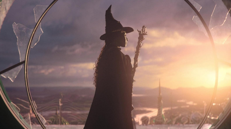 Elphaba stands by a shattered window in "Wicked" (2024)