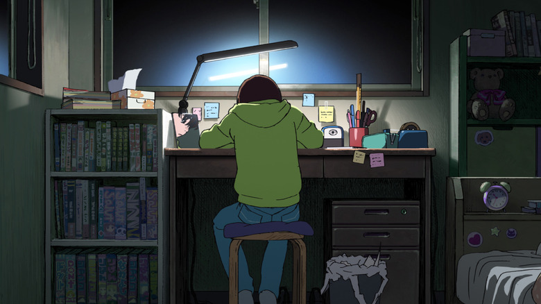 Fujino sits at a desk in her room in "Look Back" (2024)