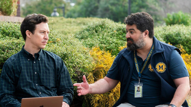 Markie (right) discussing something with his coworker Evan (left) on a bench outside