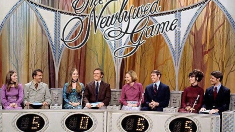 Four smiling couples sit under a sign that reads The Newlywed Game