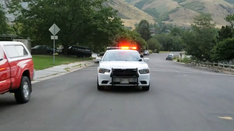 Police car running down a street on America's Most Wanted