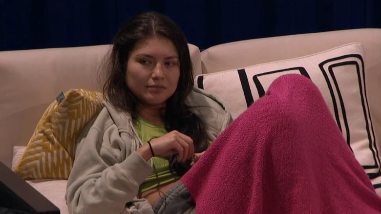 America Lopez sitting on the couch with a blanket over her legs on Big Brother