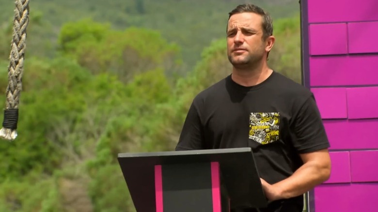 T. J. Lavin standing behind a lectern on The Challenge