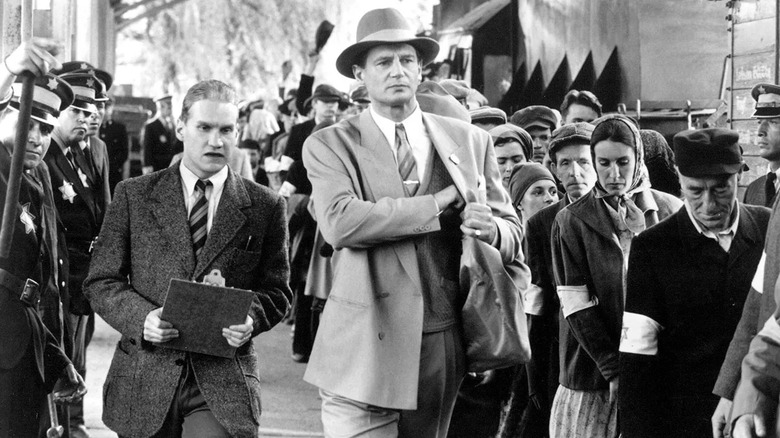 Schindler walking through a train station