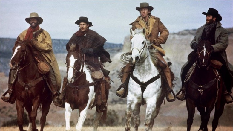 Four cowboys riding together