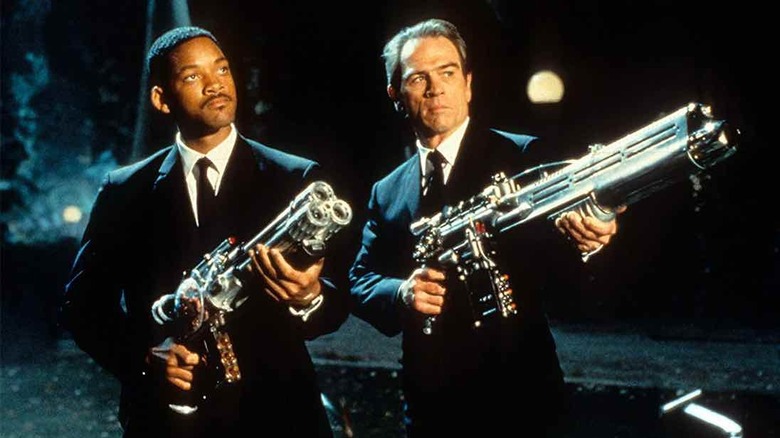 Agent J and Agent K holding guns outside (1997)