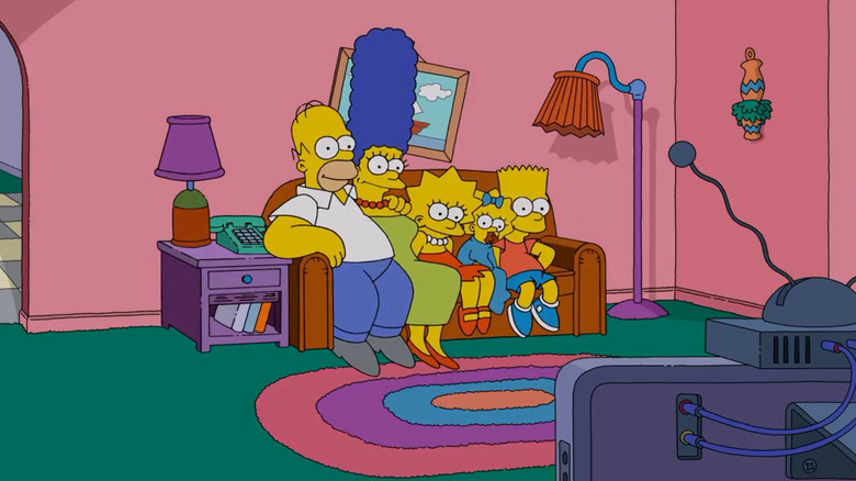 The Simpson family sits on the living room couch