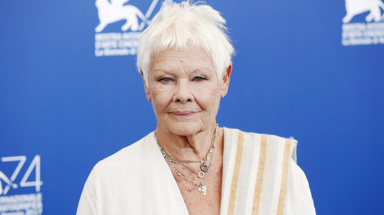 Judi Dench in white posing for photos