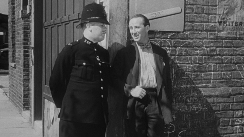 Policeman talking to man on street