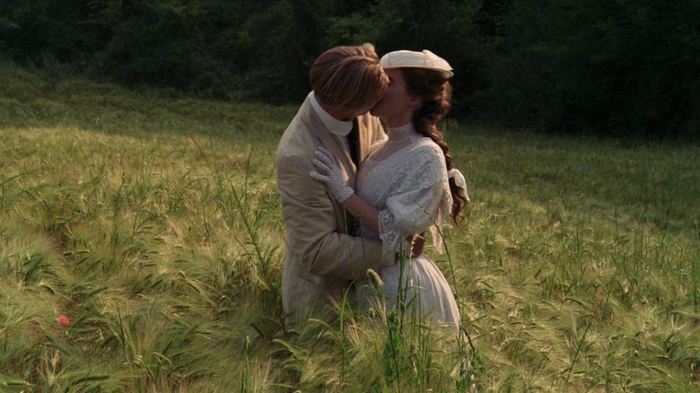 Couple kissing in the middle of a field 