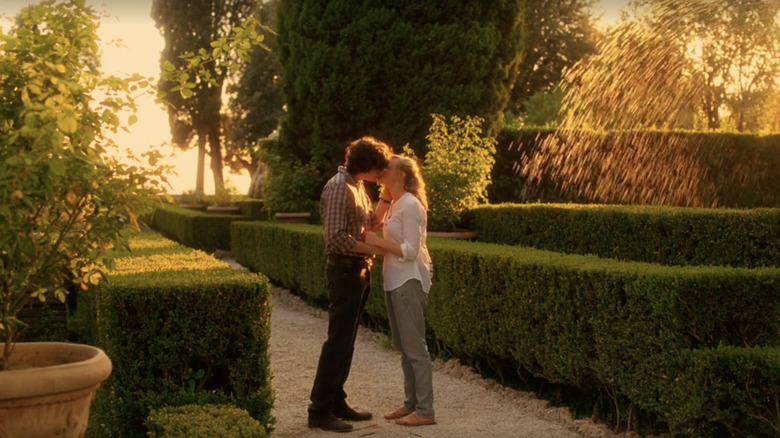 Couple kiss in the middle of a garden