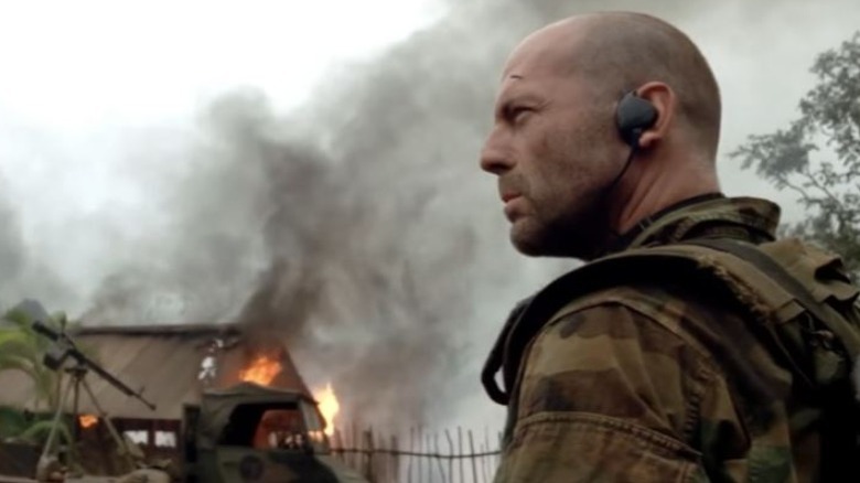 Bruce Willis looking at burning house