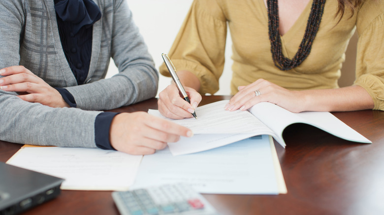 Two people signing a contract