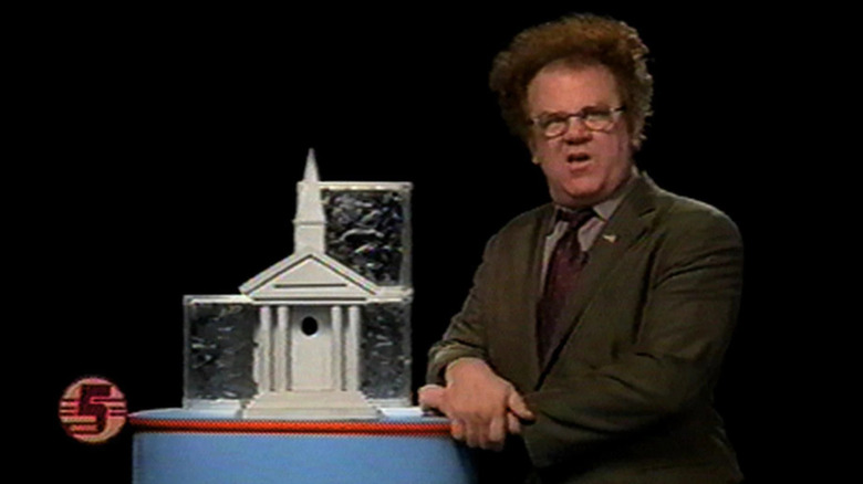 Steve Brule beside model house