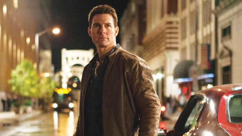 Tom Cruise stands in the street