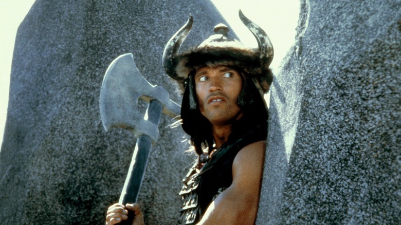 Conan holds an axe and looks to side