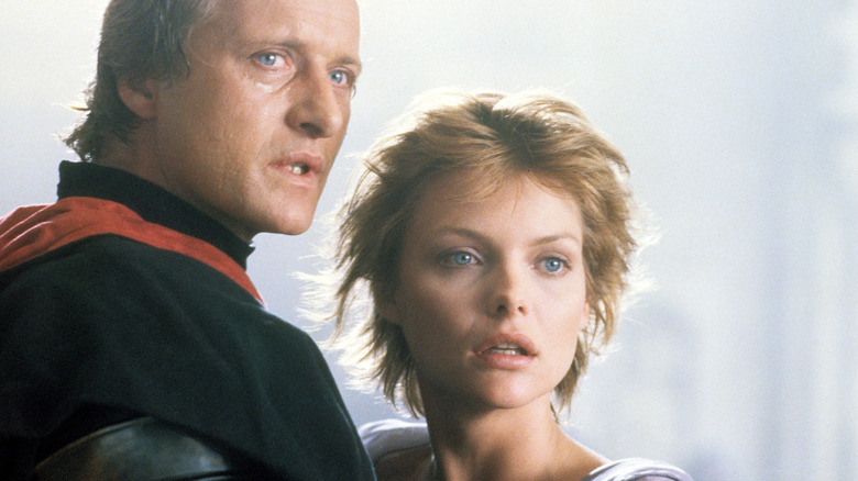 Shocked Rutger Hauer and Michelle Pfeiffer look off camera