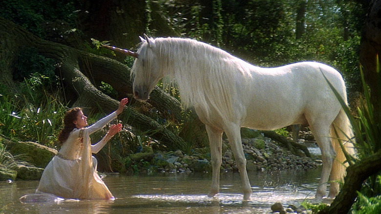 Princess Lili reaches up to touch unicorn