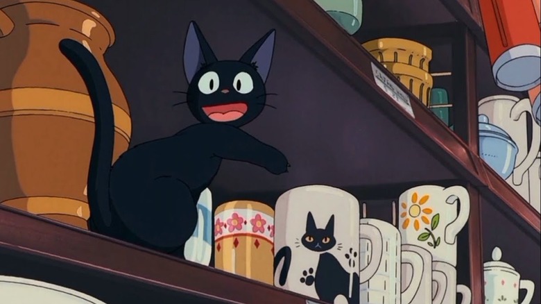 Jiji points at cat mug on shelf