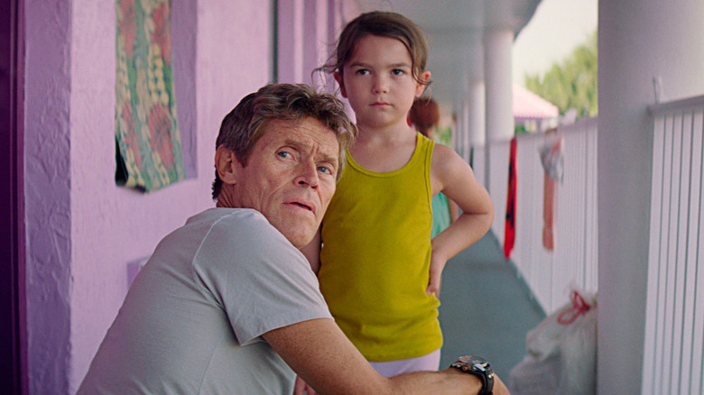 Willem Dafoe crouching by kid