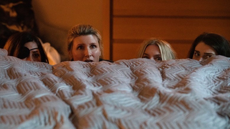 The sisters peek behind the bed