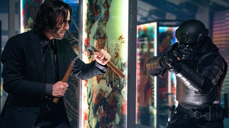 John Wick attacking armed man with nunchucks