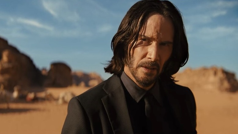 John Wick in black suit in desert