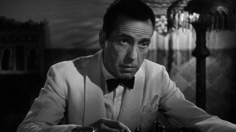 Humphrey Bogart sitting in his bar in a white tux