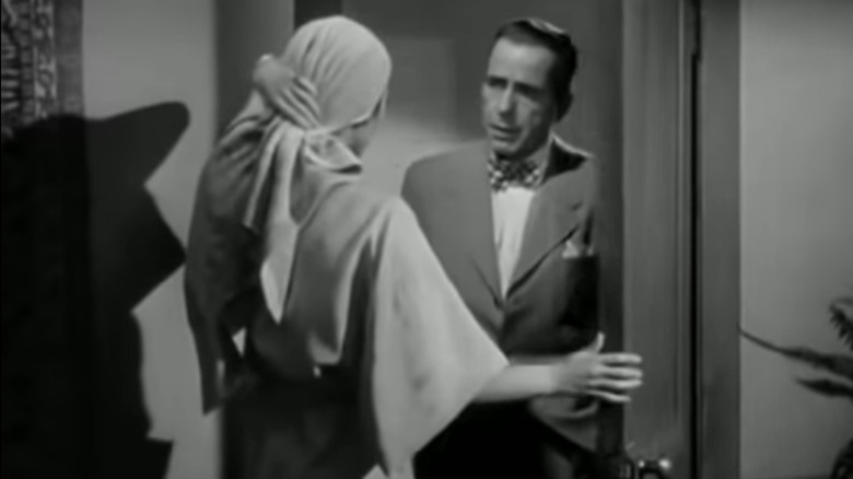 Humphrey Bogart talks to a woman in the doorway