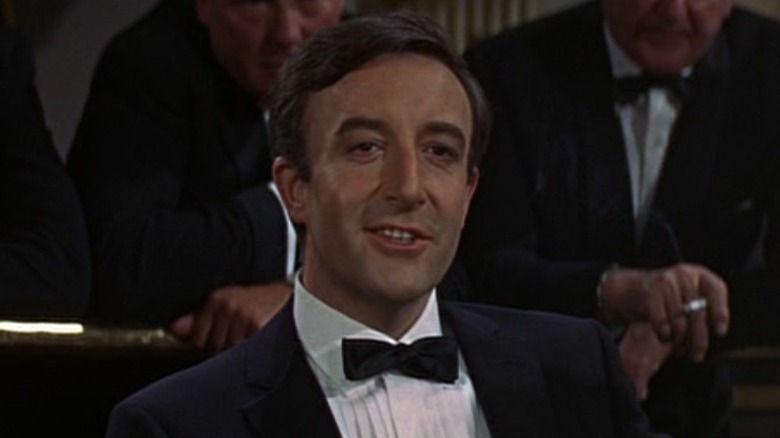 Peter Sellers smiles in a casino