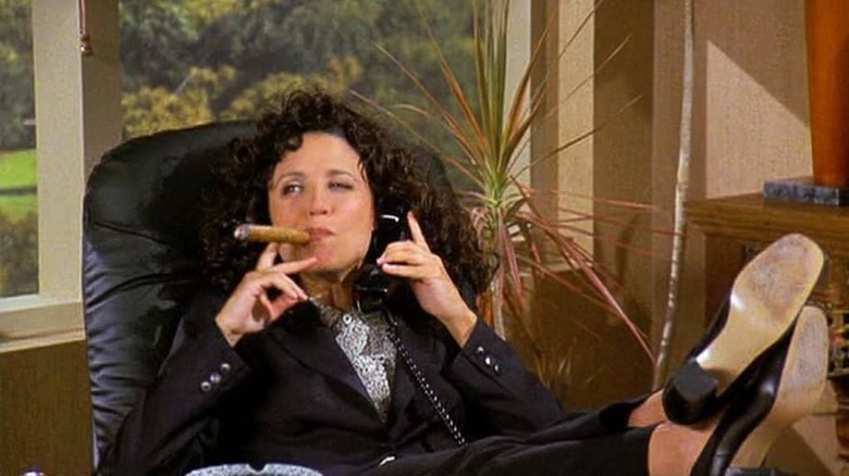 Elaine smokes a cigar