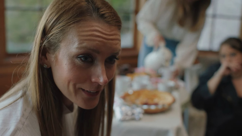 Blonde woman smiling in front of pie 