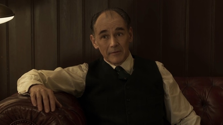 Mark Rylance sits as Leonard Burling in The Outfit