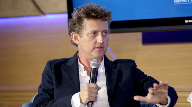 Alex Winter holding a microphone