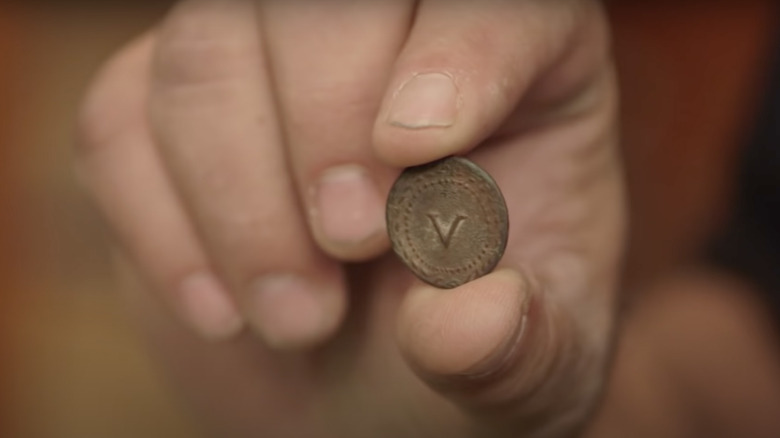 Hand holding Roman brothel token