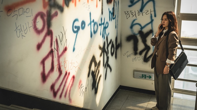 Min Hye-jin looking at graffiti