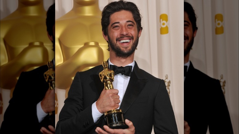 Ryan Bingham smiling with his Oscar