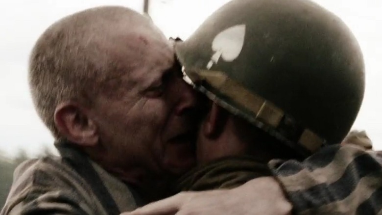 Old man hugs young soldier