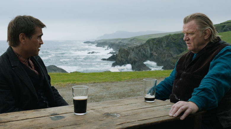 Colin Farrell and Brendan Gleeson sharing a pint near the shore