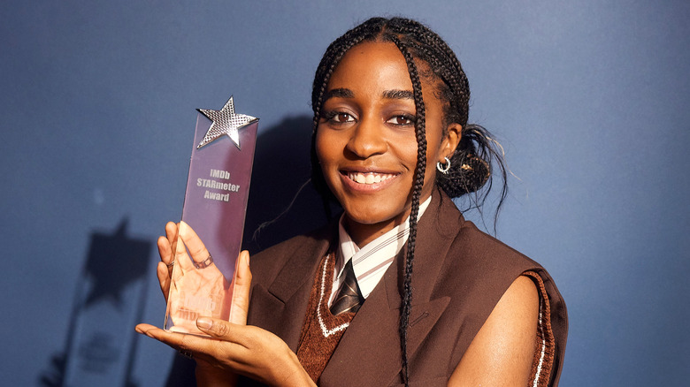 Ayo Edebiri holds an award. 