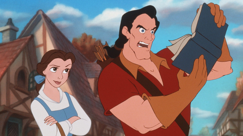 Belle looks on bemused as Gaston reads a horrifying book