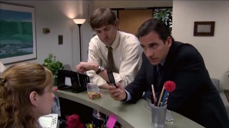 Michael Scott holds flip phone