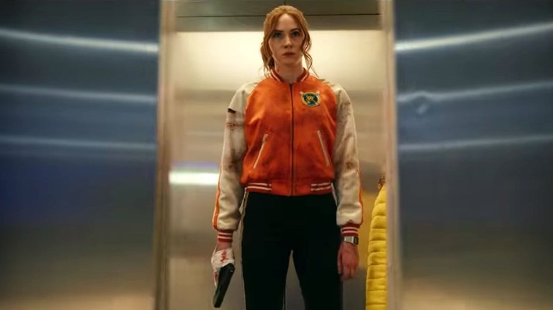 Karen Gillan holding gun in an elevator