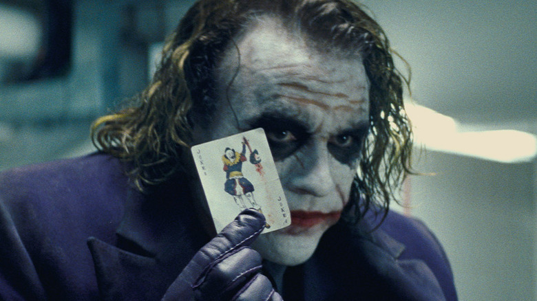 Joker holding a playing card