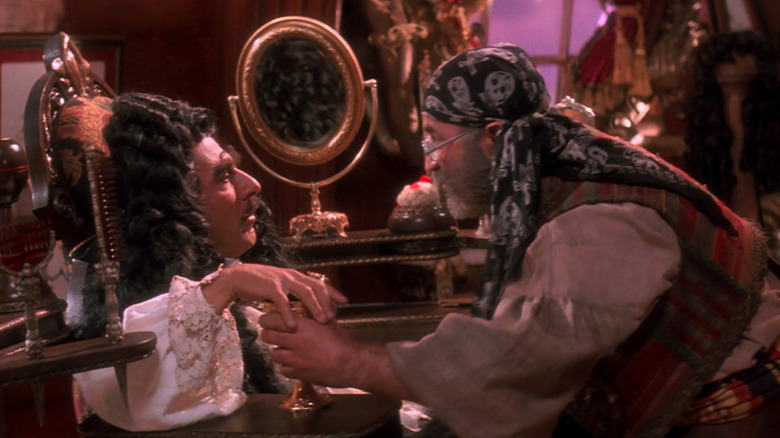 Smee hands Captain Hook a drink