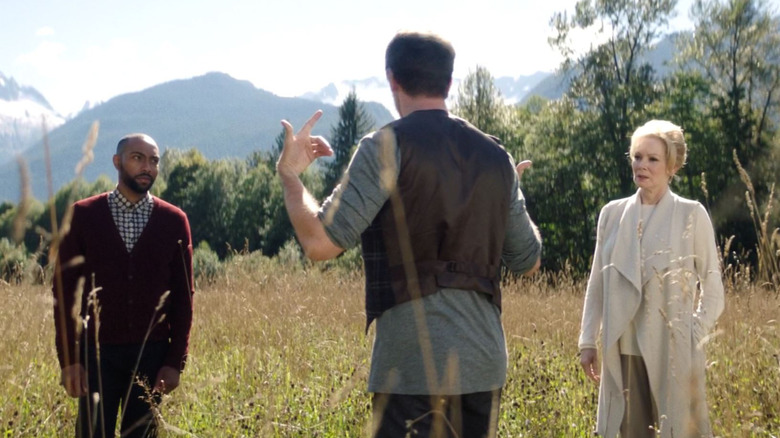 David, Melanie, and Ptonomy stand in a field