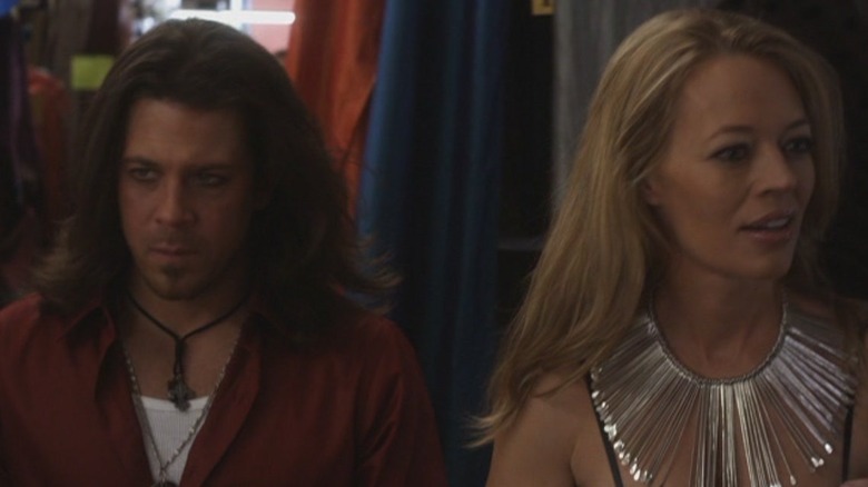 A man and woman stand backstage at a fashion show