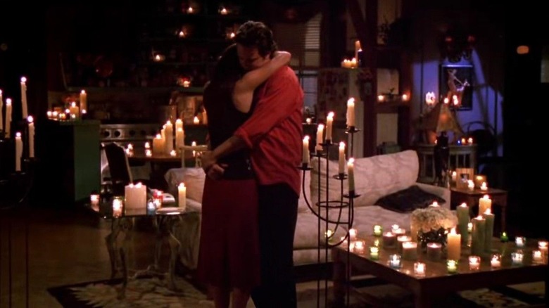 Chandler and Monica hug amongst candles